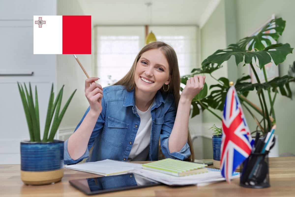 Une jeune femme souriante tenant un drapeau de Malte.