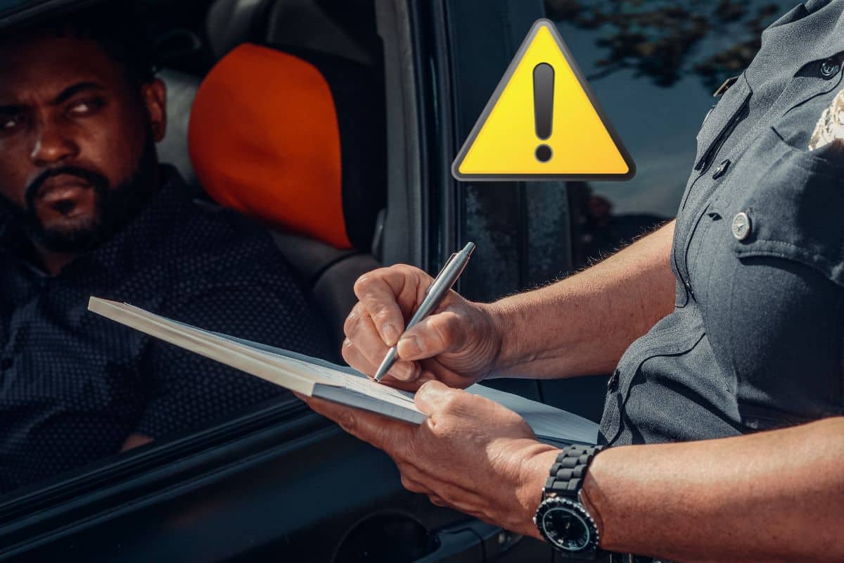 Un policier rédige une amende pour un conducteur à un péage.