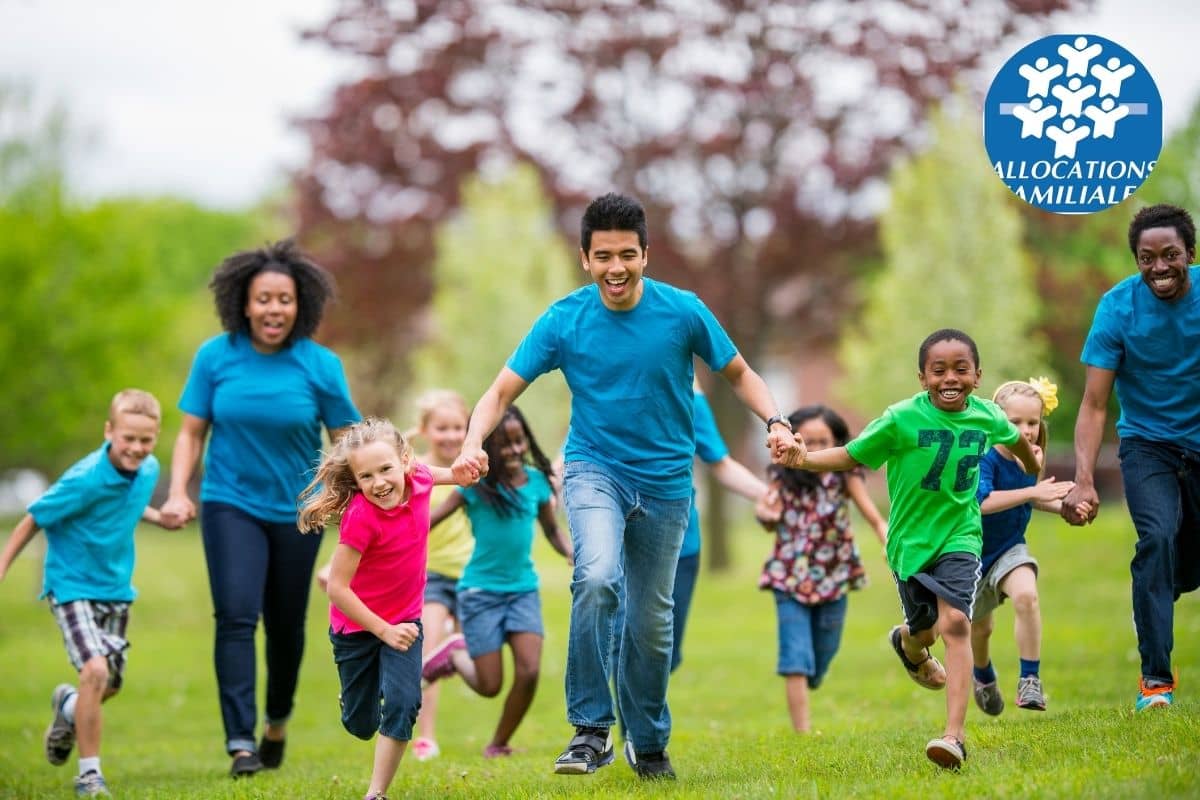 Un groupe d'enfants et d'adultes souriants courant dans un parc