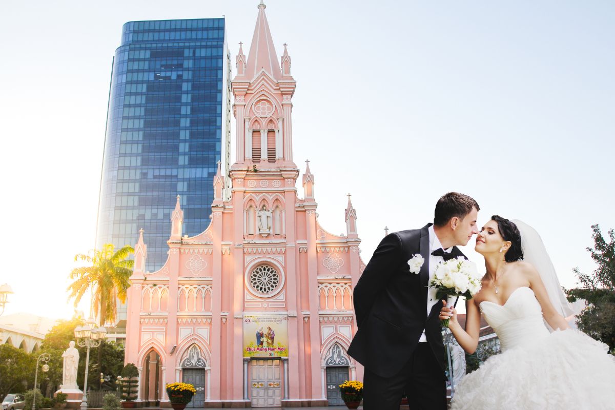 Un couple de mariés s'embrassant devant une église à Da Nang.