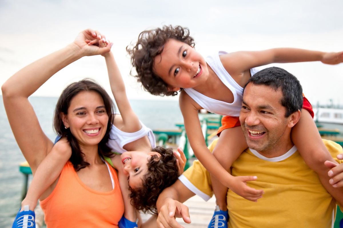 Famille souriante avec deux enfants s'amusant en vacances