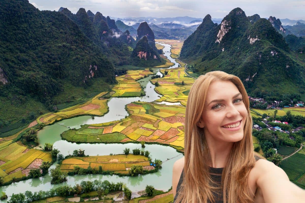 Une femme souriante prend un selfie devant des rizières en terrasse au Vietnam.